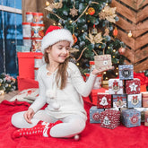Child smiling with Christmas Advent Calendar 2025 gift boxes in festive holiday setting.