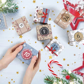 Hands holding a gift box from the Christmas Advent Calendar 2025 on a festive table with other decorated boxes.